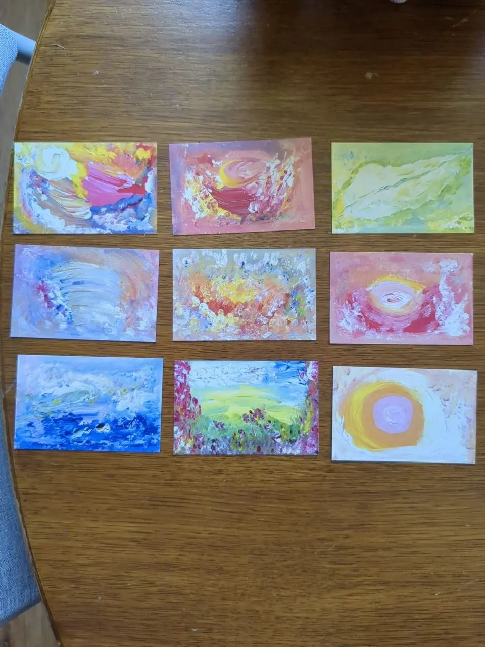 Een reeks koesterkaartjes naast elkaar op tafel, in zachte pasteltinten
